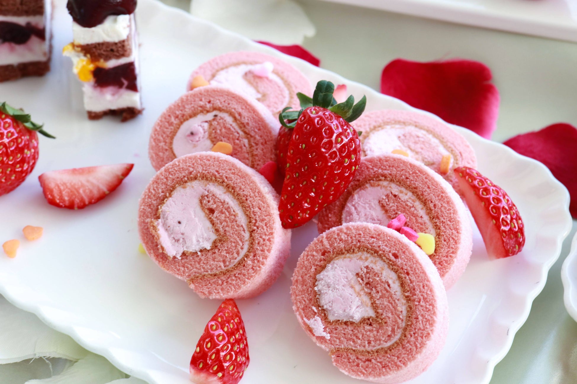 ピンク色のスポンジ生地をとちおとめのクリームで巻き上げたロールケーキ