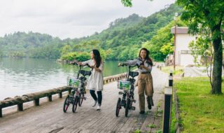 ©︎十和田奥入瀬観光機構　※4月1日から自転車利用者のヘルメット着用が努力義務化されました。運転の際、ご持参またはE-Bikeに備え付けのヘルメットをご着用ください。