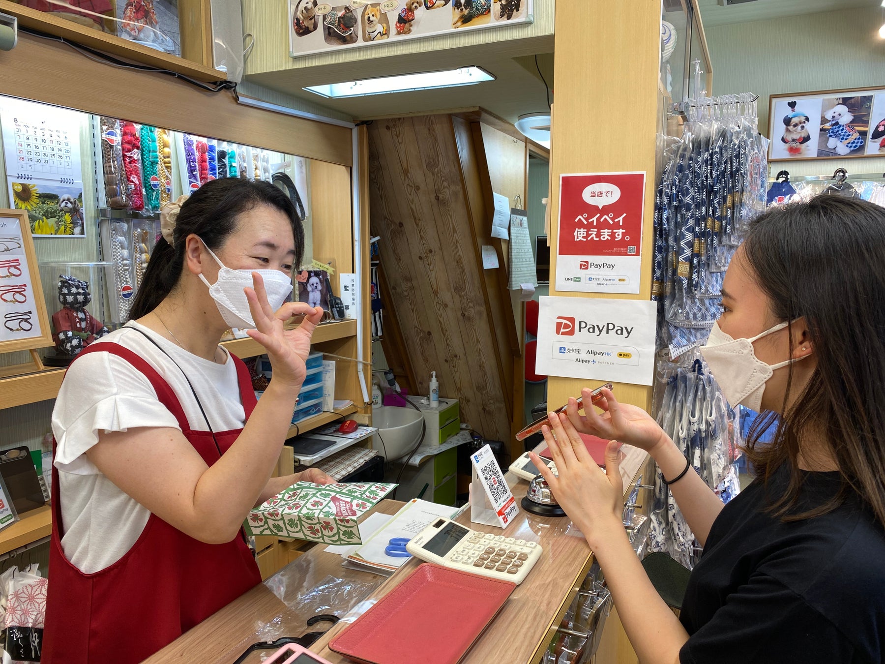 浅草の仲見世商店街でアリペイを利用してペット用の着物を購入する中国人観光客