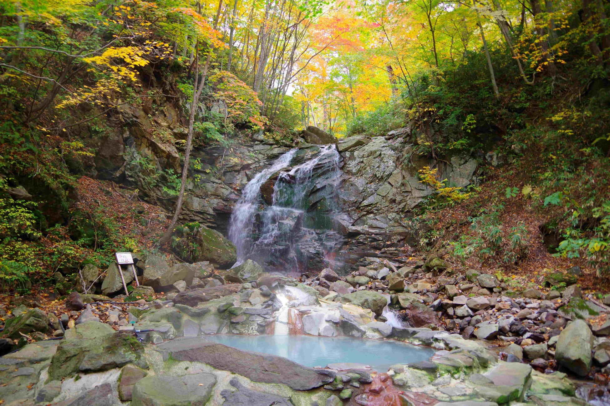 混浴野天風呂「仙女の湯」は、紅葉に染まる森の中の「亀滝」や「湯ノ沢」のせせらぎが心地好いロケーションにあります