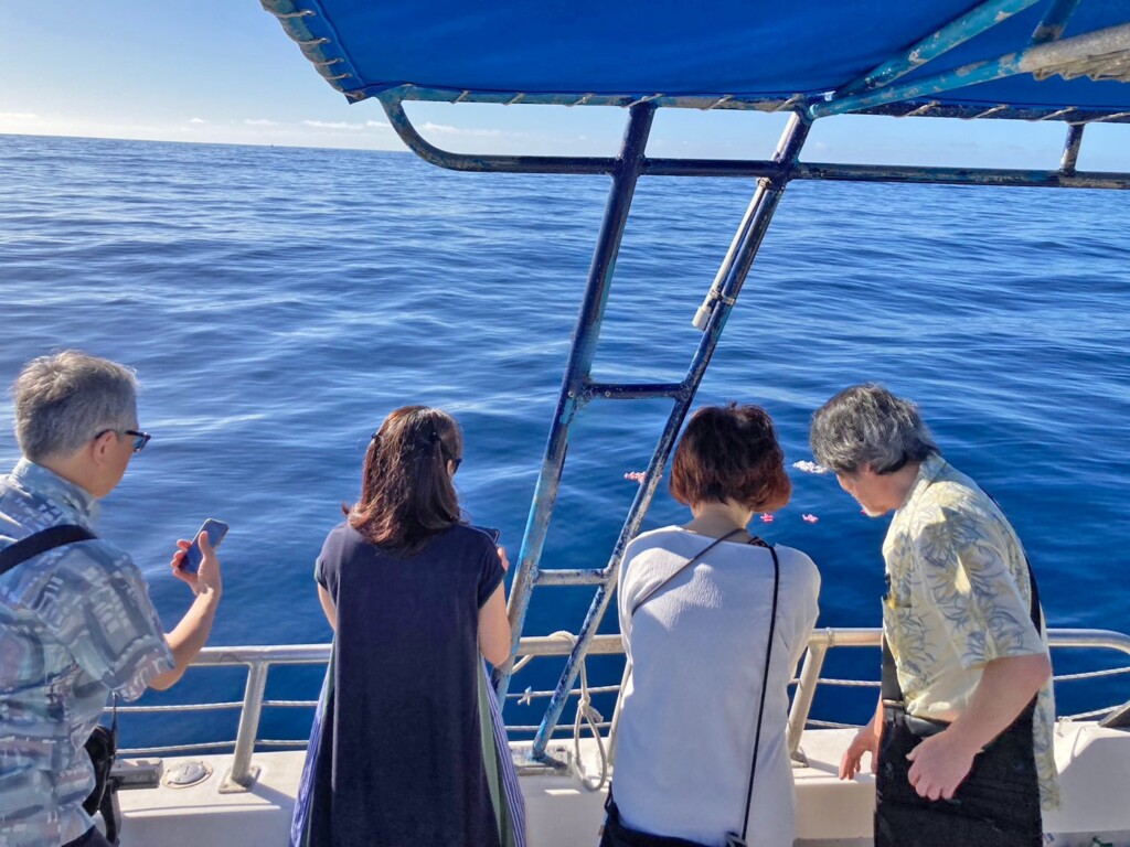 ハワイの海で散骨を行う遺族