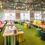 ＢＥＢ５沖縄に推し活スタジアムルームの雰囲気を楽しむ様子。野球場の装飾やインテリアが施されたラウンジで、ファン同士が交流するシーンを描いています。