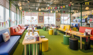 ＢＥＢ５沖縄に推し活スタジアムルームの雰囲気を楽しむ様子。野球場の装飾やインテリアが施されたラウンジで、ファン同士が交流するシーンを描いています。